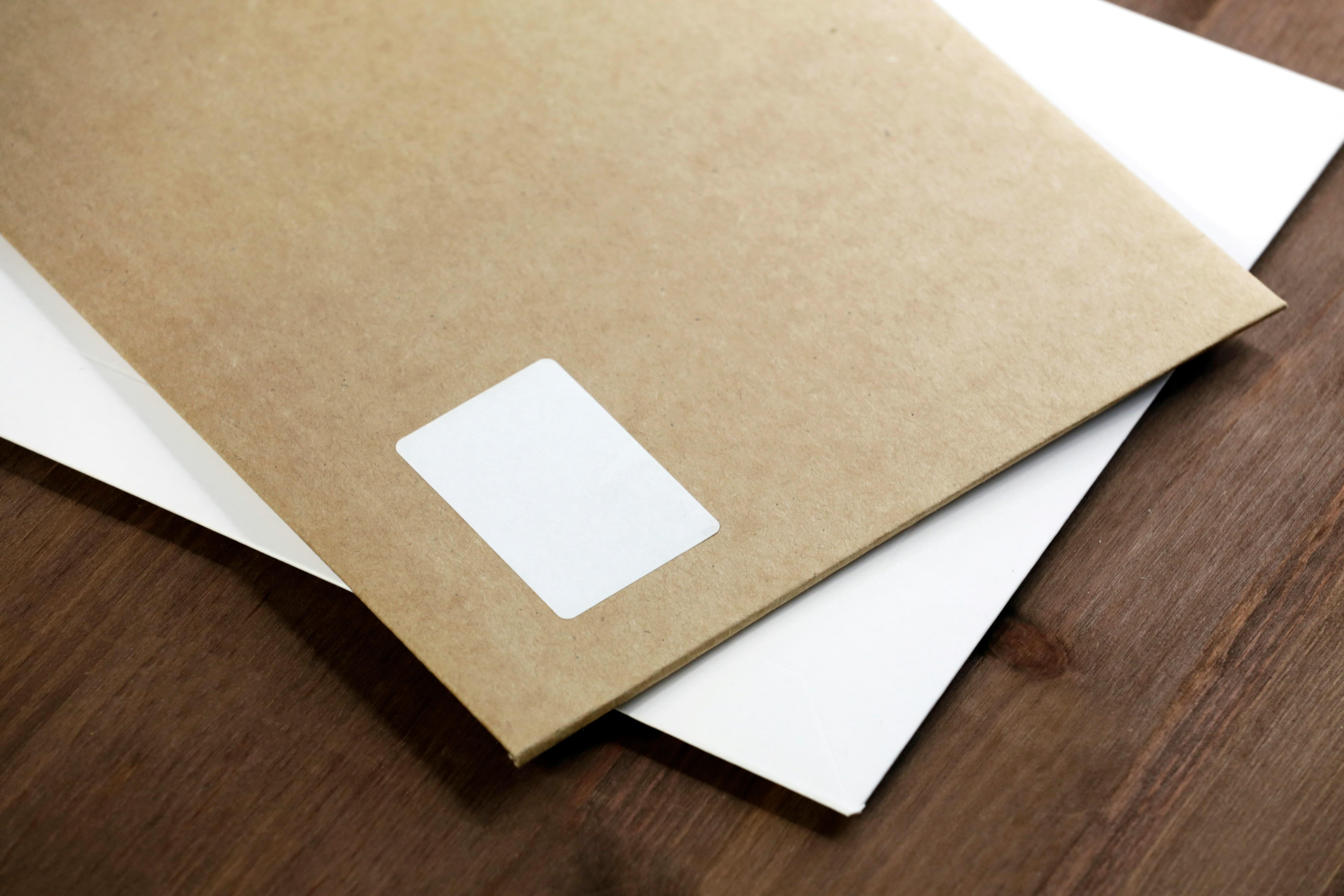 close up of envelopes of alternating colours on a wooden table
